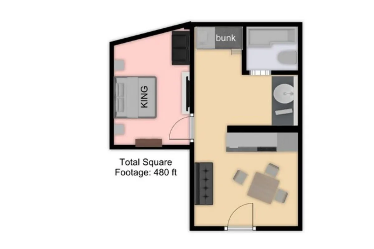 This image captures a bright, inviting space that features both a plush KING bed and a set of bunk beds in the background. There's a dining table visible, suggesting a shared, communal area ideal for families. The bedding looks fresh and comfortable, and the layout makes the space feel open yet cozy.