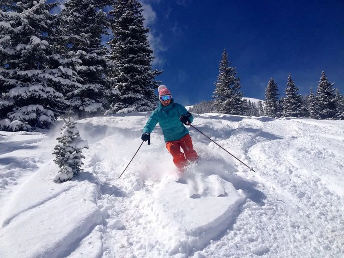 An energetic winter scene showcasing a skier gliding through a snow-covered landscape surrounded by pine trees, with stunning mountain views in the background. The mood is adventurous and joyful, emphasizing outdoor activity and shared experiences.